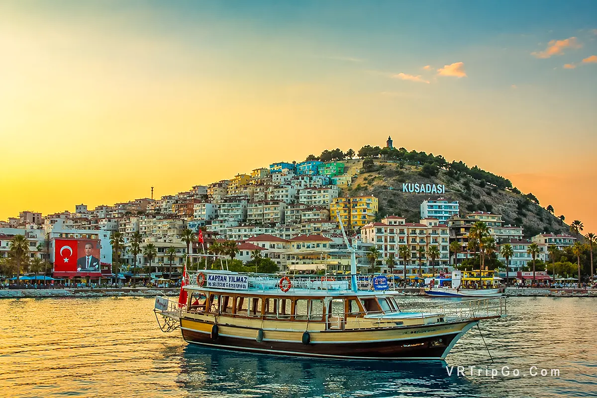 Best Time to Visit Kusadasi sunset harbor view with traditional boat and coastal cityscape in Turkey