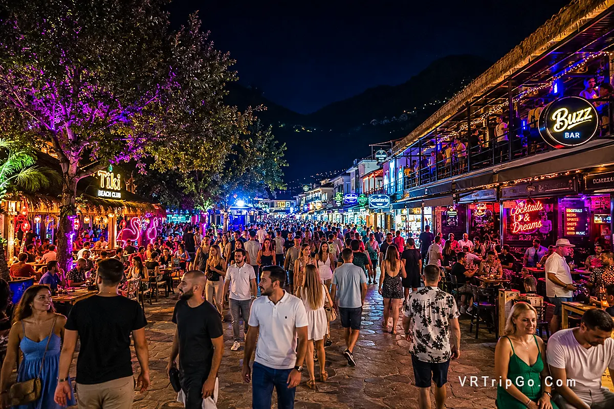 Nightlife in Oludeniz with crowded beach bars, live music atmosphere, colorful evening lights and vibrant Mediterranean party scene near the coast.