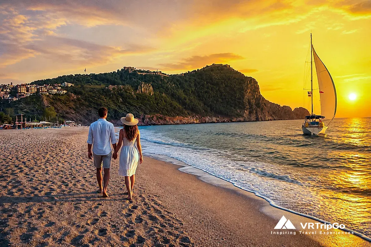 Best time to visit Alanya for beach holidays – couple walking on sandy beach at sunset with warm golden sky and calm sea