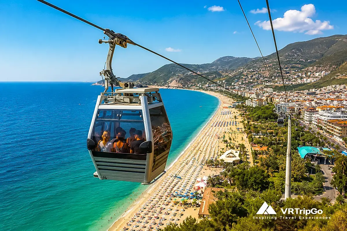 Alanya cable car ride over Cleopatra Beach with tourists inside gondola, panoramic coastal views and castle scenery, Alanya Castle and cable car tour experience
