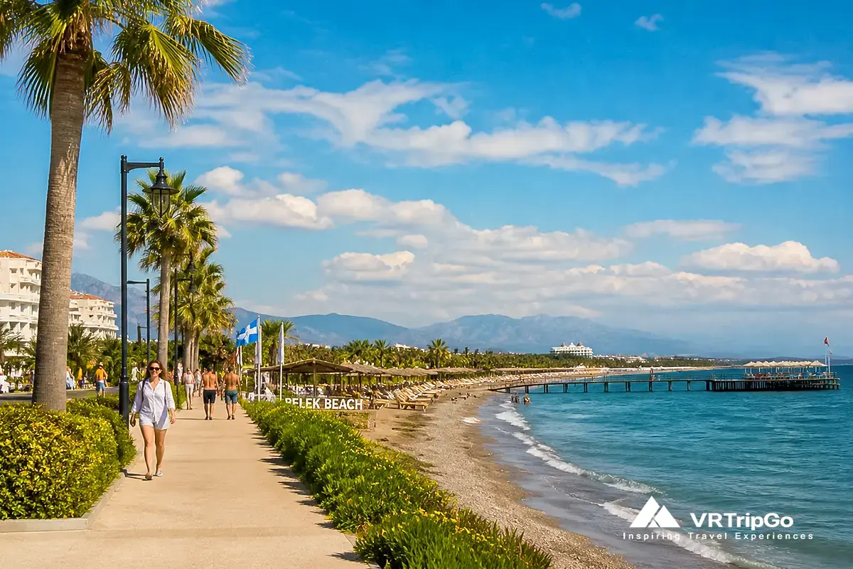 Belek beach promenade in autumn weather, warm sunny day with light clouds, palm trees and resorts, people walking along the seaside, calm turquoise sea, Antalya Turkey