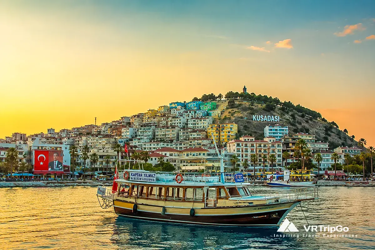 Best Time to Visit Kusadasi sunset harbor view with traditional boat and coastal cityscape in Turkey