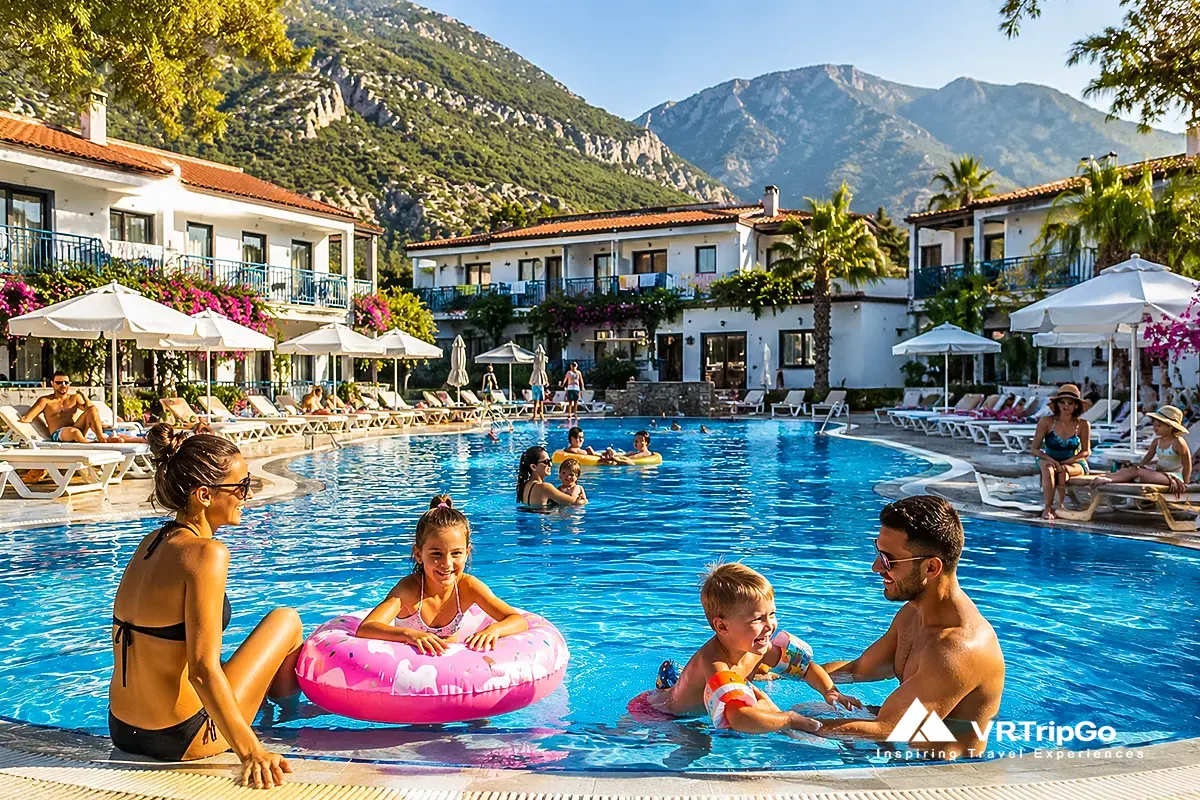 Best family hotels in Oludeniz with large swimming pool, children playing, family-friendly resort atmosphere and mountain views near the Mediterranean coast.