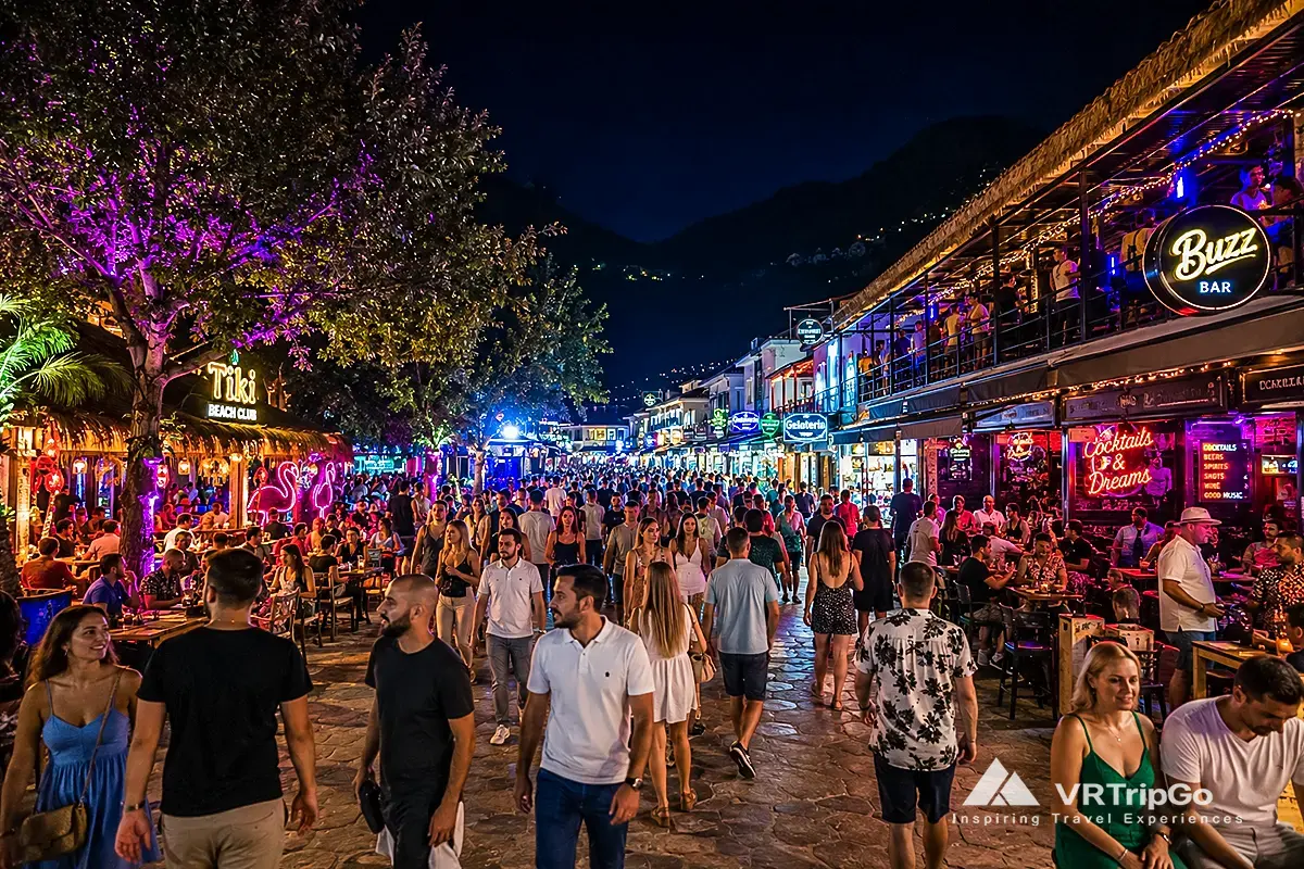 Nightlife in Oludeniz with crowded beach bars, live music atmosphere, colorful evening lights and vibrant Mediterranean party scene near the coast.