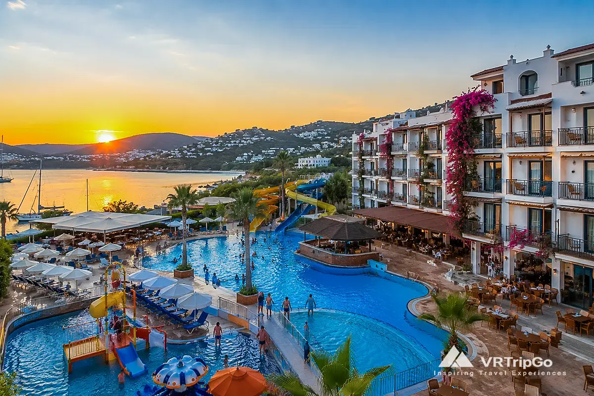 Best Family Hotels in Bodrum beachfront resort with kids pool, water slides and family friendly hotel at sunset in Turkey