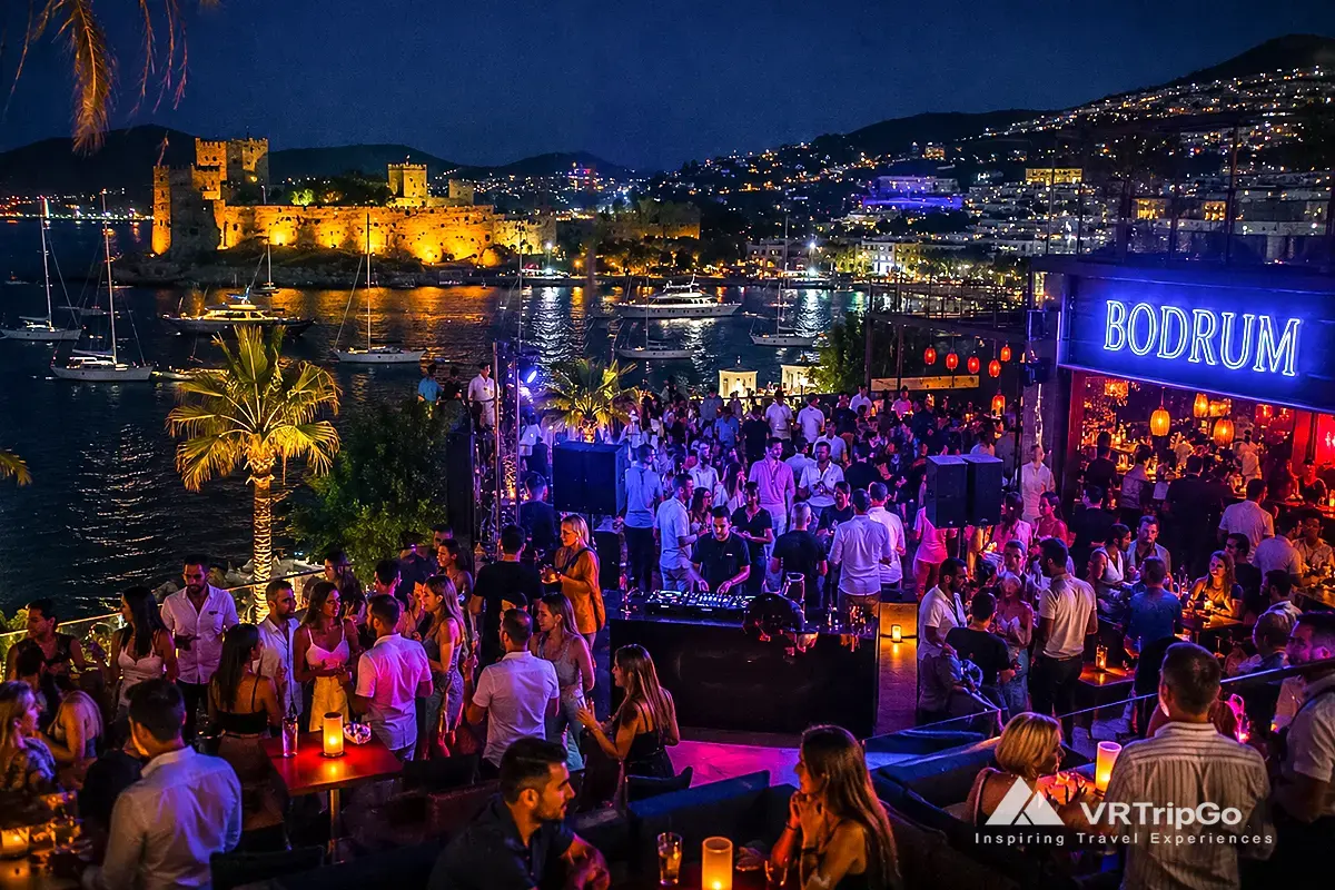 Nightlife in Bodrum luxury beach club party with vibrant crowd, neon lights and marina view at night in Turkey