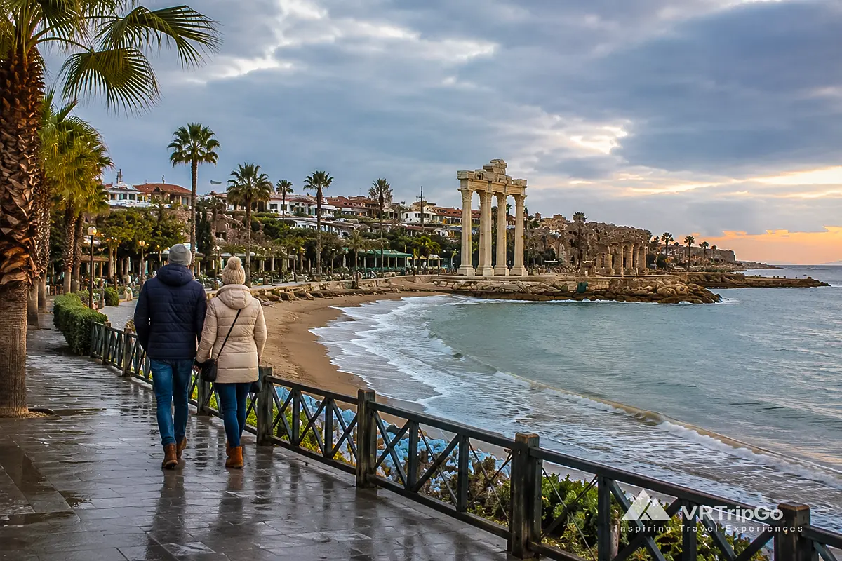 Side Weather in Winter: Couple Walking Along the Seafront Near the Temple of Apollo During a Mild Winter Day in Side, Turkey