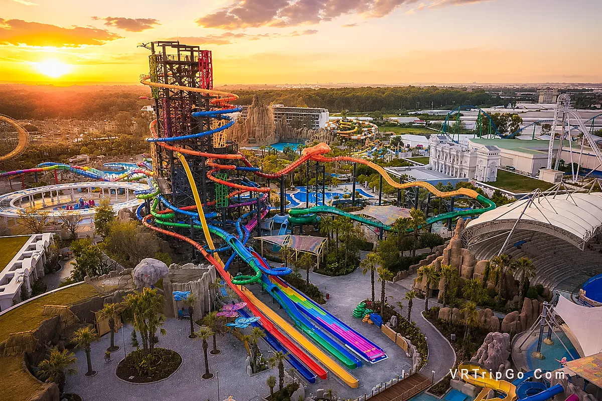 Land of Legends Theme Park Tour at sunset featuring colorful water slides, thrilling attractions, palm-lined pathways, and a spectacular aerial view of Turkey’s famous adventure park.