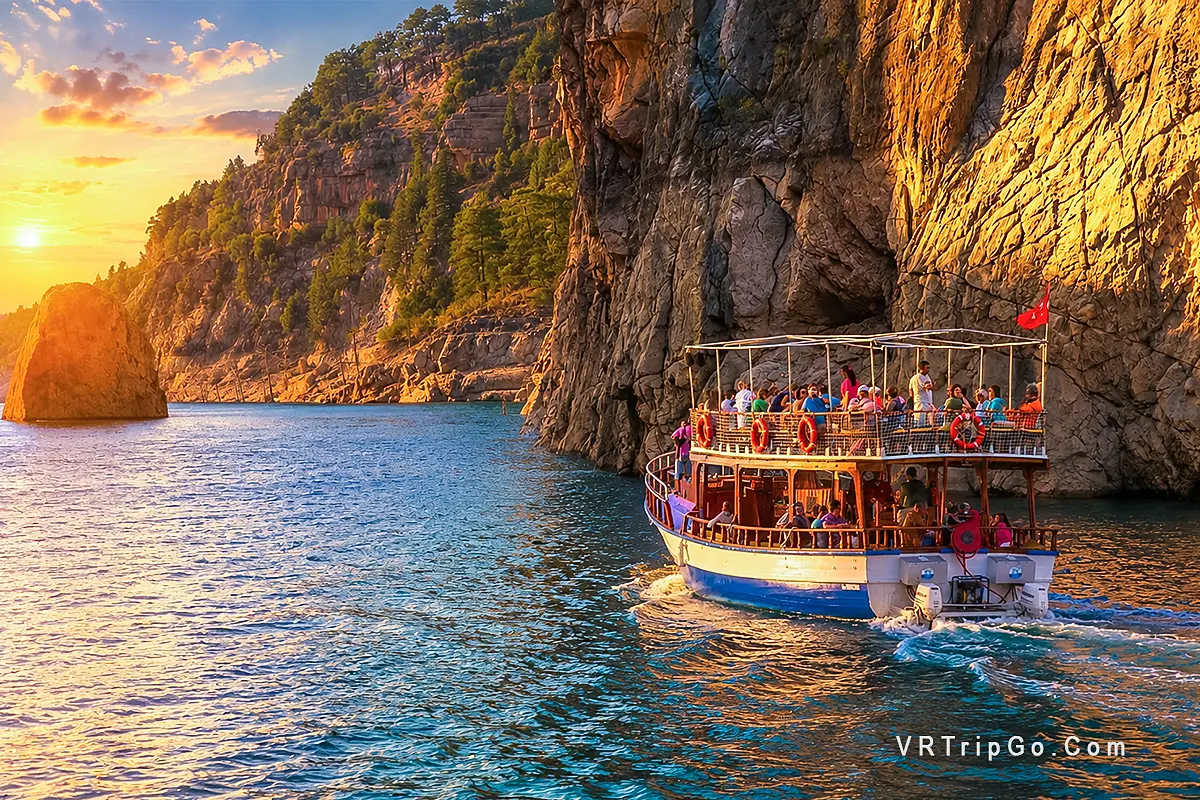 Green Canyon Boat Trip through dramatic cliffs and crystal-clear waters at sunset, featuring a traditional sightseeing boat, stunning canyon scenery, and a relaxing nature cruise experience.