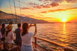 Altinkum Sunset Cruise with Guests Photographing a Spectacular Aegean Sunset from the Boat Deck