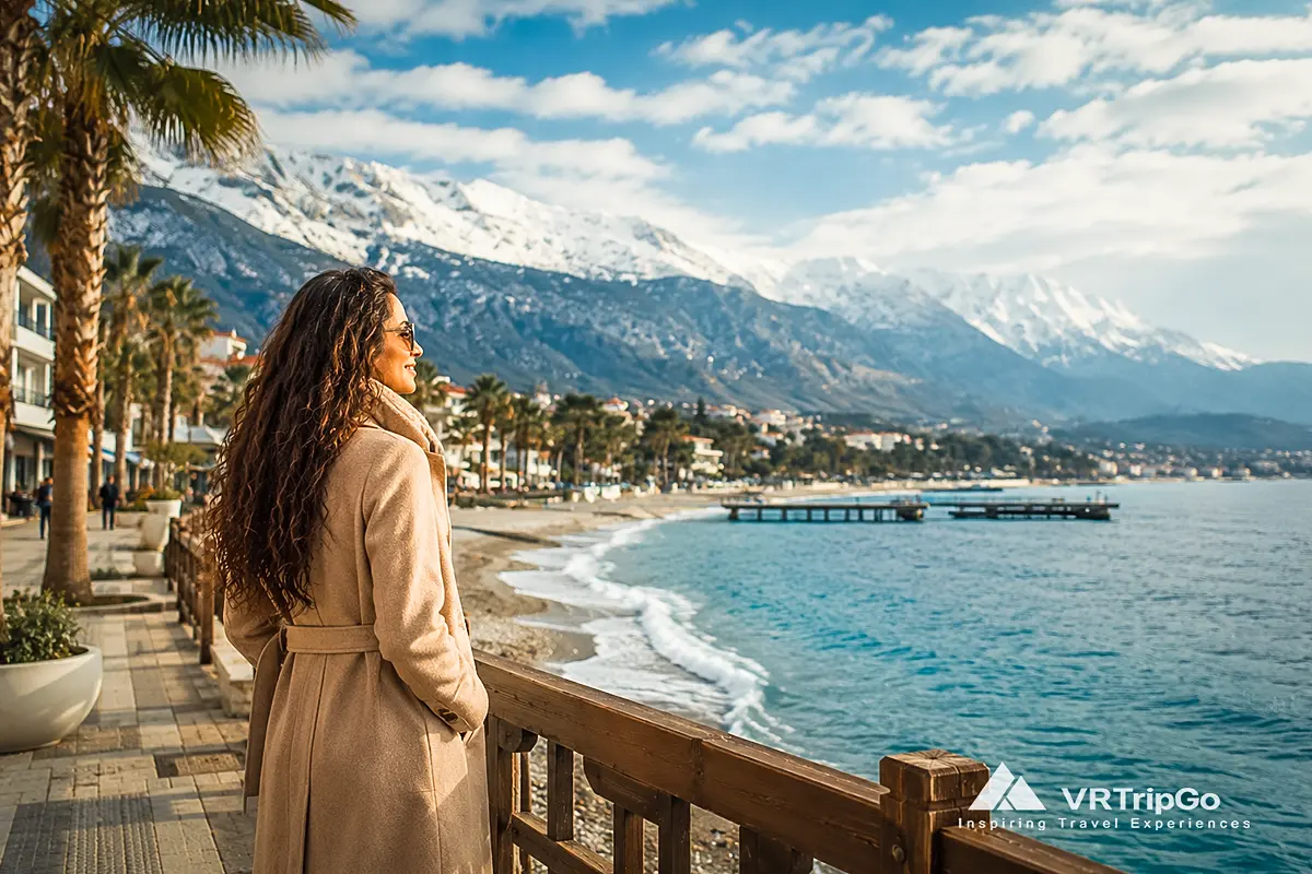 Kemer Weather in Winter: Woman Enjoying the Seaside Promenade with Snowy Taurus Mountains in Kemer, Turkey During a Sunny Winter Day